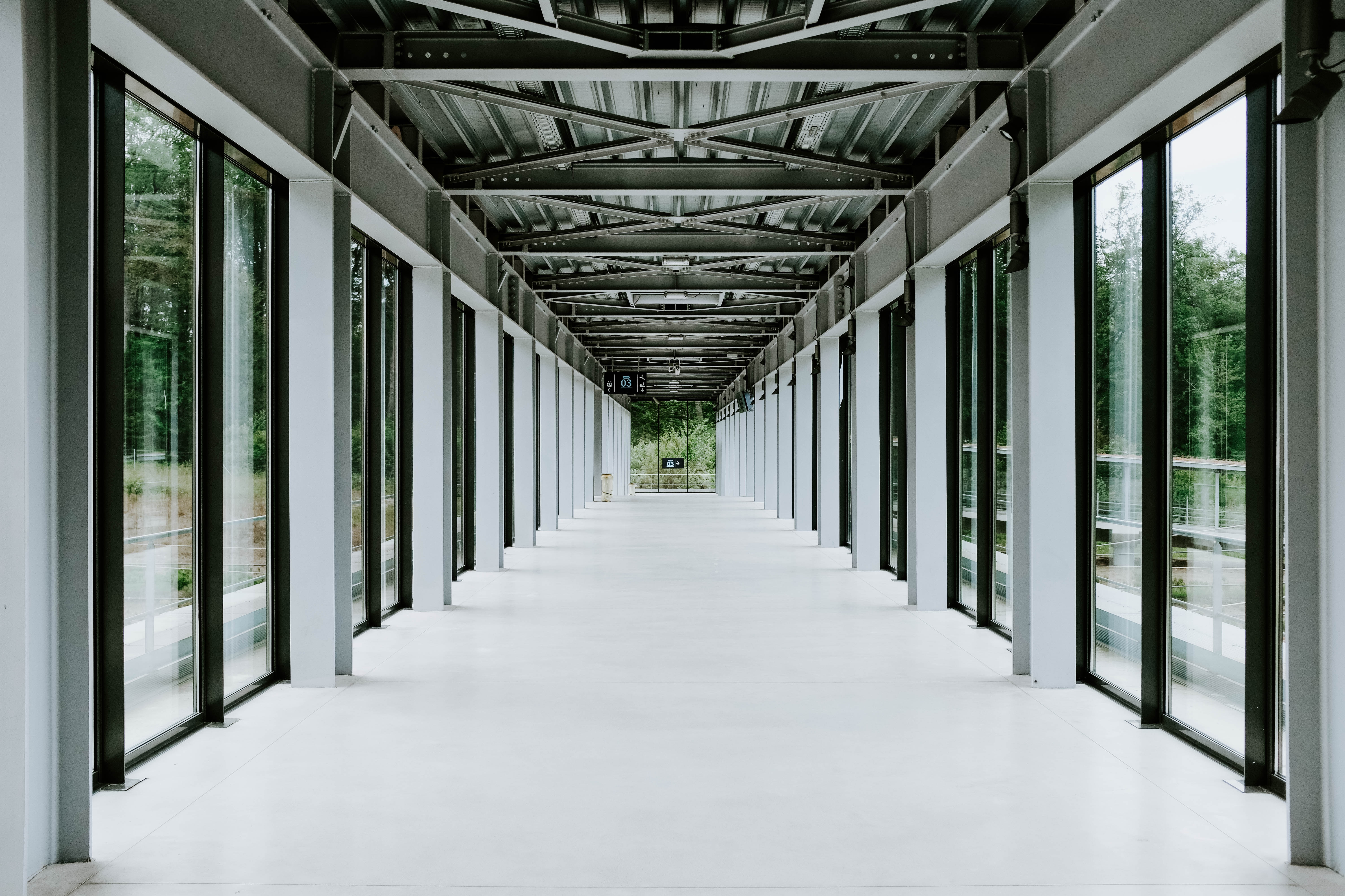 white-hallway-with-glass-doors-metal-ceiling-modern-building